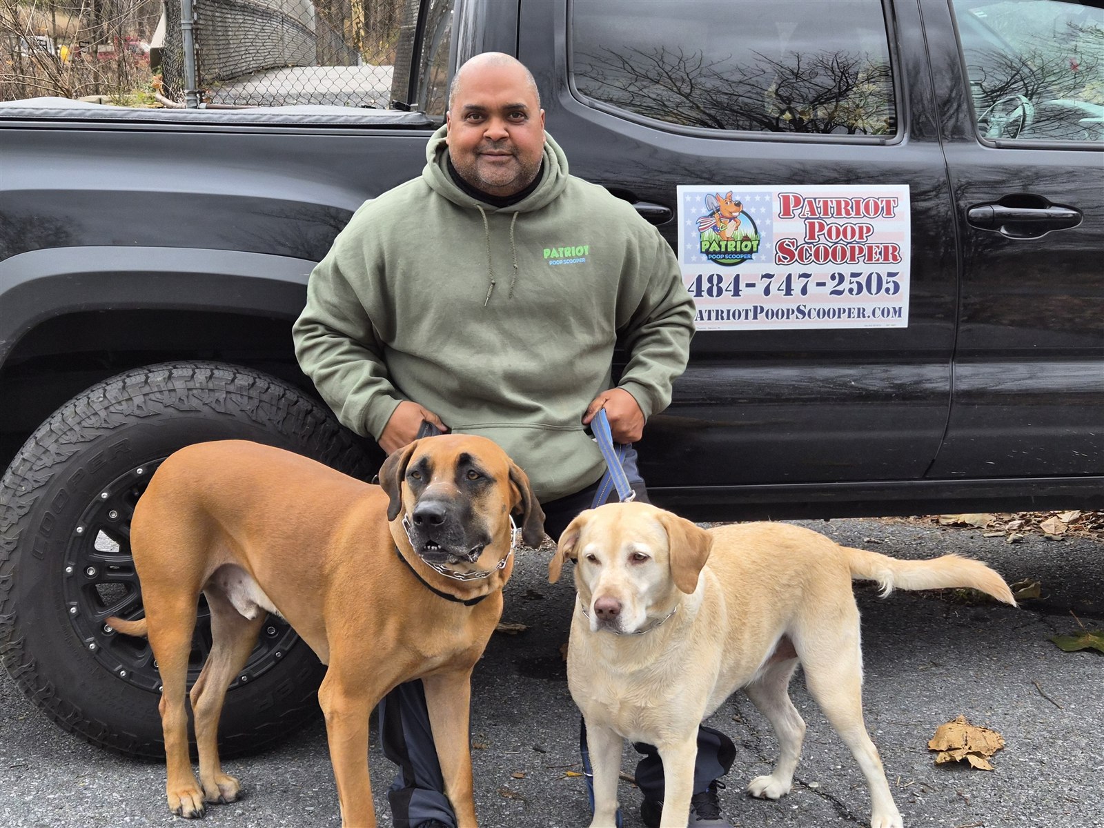 David Flores with his two dogs beside the branded Patriot Poop Scooper truck